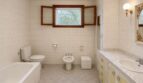 Bright retro bathroom with bathtub, bidet, toilet and marble sink in Villa Porto Cristo.