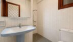 Bright bathroom of the retro villa in Porto Cristo with pedestal sink, shower and mosaic tile floor.