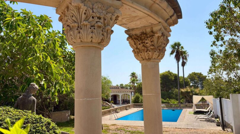 Classic columned arbor with view of the pool of the retro villa in Porto Cristo