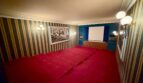 Cinema room with red carpet, striped wallpaper, wall lights and projection screen in Retro-Villa Porto Cristo.