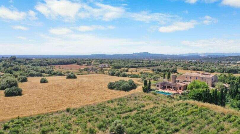 Luftaufnahme einer Finca mit Pool in Felanitx, umgeben von Weinbergen, Olivenhainen und weiter Landschaft.