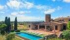 Außenansicht der Finca mit Pool, Liegestühlen, Pergola und historischem Windmühlenturm in Felanitx