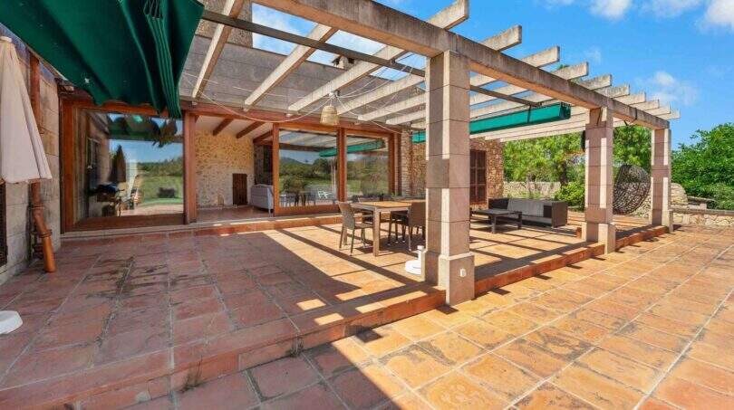 Sonnige Terrasse mit Pergola, Natursteinboden und Lounge-Bereich der Windmühlen-Finca in Felanitx