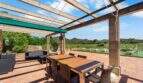Überdachte Terrasse mit Holztisch, Rattanstühlen und Panoramablick auf Felanitx und Sant Salvador