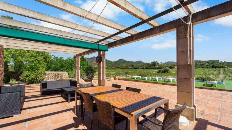 Überdachte Terrasse mit Holztisch, Rattanstühlen und Panoramablick auf Felanitx und Sant Salvador