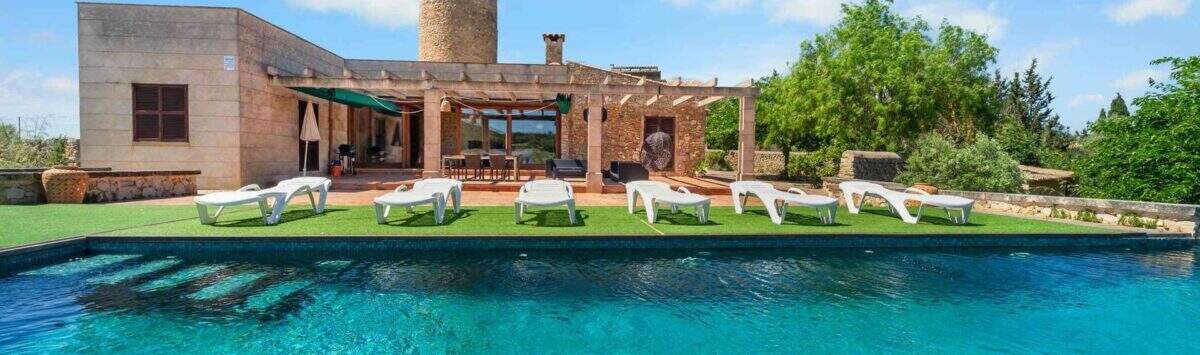 Außenpool mit Liegestühlen und historischer Windmühle einer Finca mit ETV-Lizenz in Felanitx, Mallorca