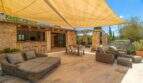 Sunny terrace of the Felanitx finca with sail shade, lounge, outdoor kitchen and stone arches