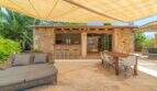 Covered outdoor terrace of the Felanitx finca with lounge, dining table and rustic stone bar