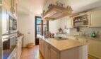 Kitchen of the Felanitx finca with cooking island, granite countertops, built-in appliances and terracotta floor