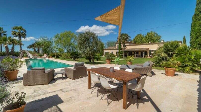 Sunny terrace with pool, dining table and lounge of the exclusive finca in Felanitx