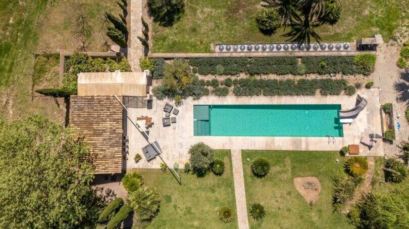 Aerial view: Rectangular pool with terrace, lounge furniture and well-maintained garden of the Felanitx finca