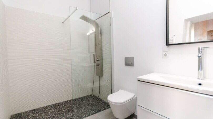Modernes weißes Badezimmer mit Glasdusche, Hänge-WC und elegantem Waschtisch im Stadthaus Felanitx