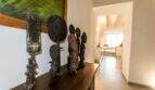 Flur des Stadthauses in Felanitx mit afrikanischen Holzfiguren auf Sideboard und Blick in Wohnbereich