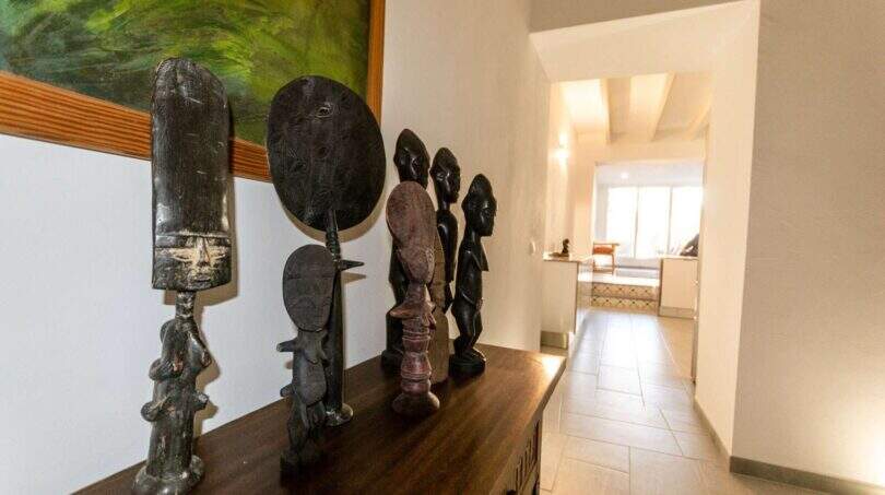 Flur des Stadthauses in Felanitx mit afrikanischen Holzfiguren auf Sideboard und Blick in Wohnbereich