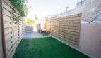 Eingezäunter Garten mit Kunstrasen und Holzsichtschutz eines Stadthauses in Felanitx