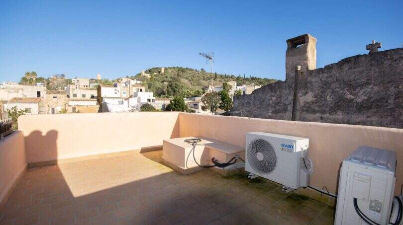 Dachterrasse des Stadthauses in Felanitx mit Klimaanlage, Blick auf Altstadt und grünen Hügel.