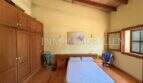 Helles Schlafzimmer der Finca in Llucmajor mit Holzboden, Einbauschrank und Holzbalkendecke.