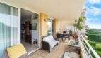 Geräumige Terrasse der Wohnung in Porto Colom mit Lounge, Esstisch und Blick auf Grünanlage