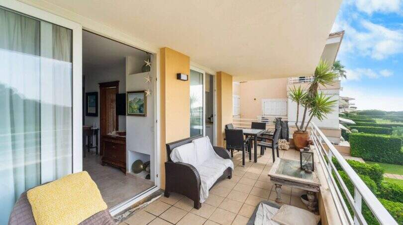 Geräumige Terrasse der Wohnung in Porto Colom mit Lounge, Esstisch und Blick auf Grünanlage