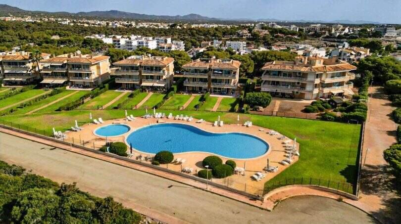 Luftaufnahme der Wohnanlage in Portocolom mit zwei Pools, gepflegten Grünflächen und mediterranen Mehrfamilienhäusern