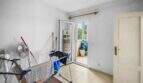 Utility-Raum der Wohnung in Porto Colom mit Wäscheständer, Ventilator und Zugang zur Terrasse.