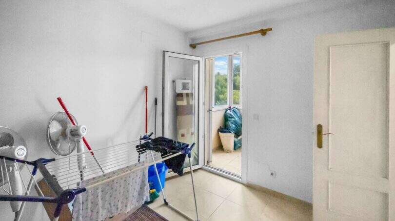 Utility-Raum der Wohnung in Porto Colom mit Wäscheständer, Ventilator und Zugang zur Terrasse.