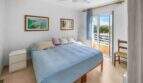 Helles Schlafzimmer der Wohnung in Porto Colom mit Doppelbett, Deckenventilator und Balkonzugang mit Meerblick