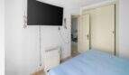 Schlafzimmer der Wohnung in Portocolom mit Doppelbett, Wand-TV und Heizkörper