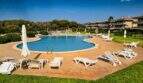 Großer Außenpool mit Liegestühlen und Sonnenschirmen der Wohnanlage in Porto Colom, Mallorca
