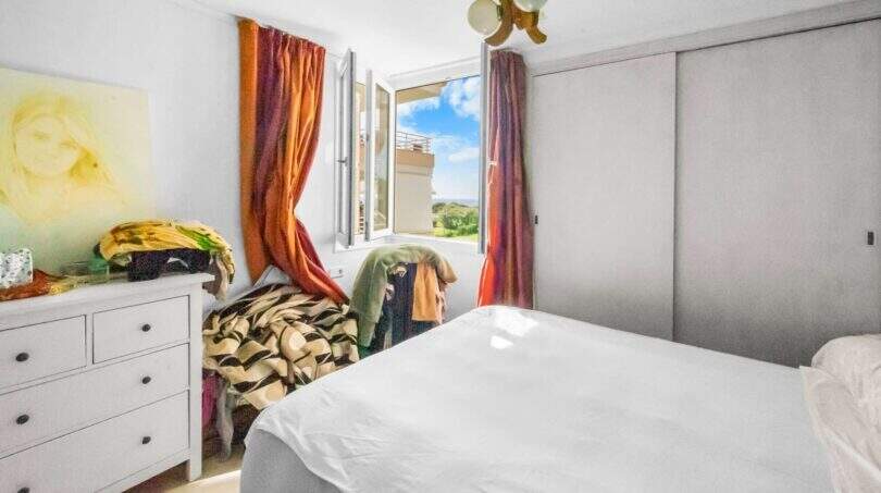 Schlafzimmer der Wohnung in Porto Colom mit Doppelbett, Kleiderschrank und Fenster mit Meerblick