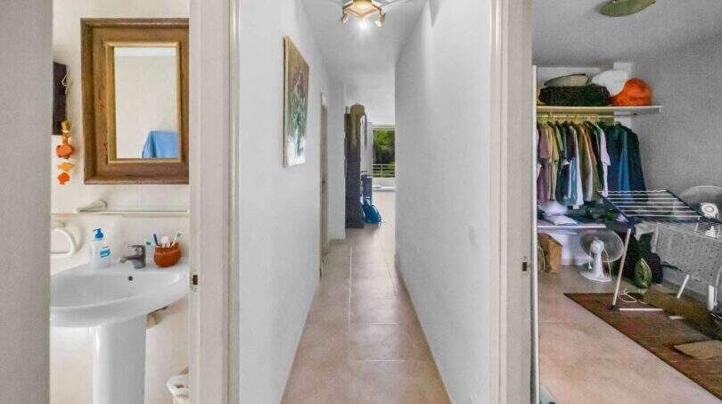 Heller Flur der Wohnung in Porto Colom mit Blick auf Bad, Ankleideraum und Ausgang zur Terrasse.