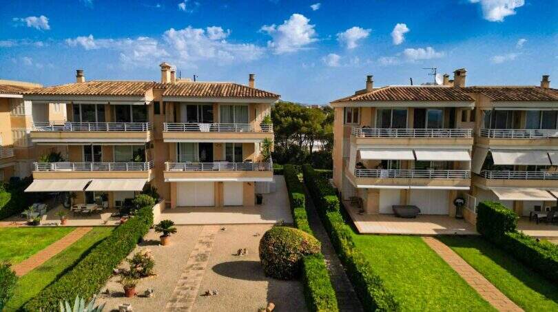 Außenansicht zweier mediterraner Mehrfamilienhäuser mit Balkonen, gepflegtem Garten und Terrassen in Porto Colom