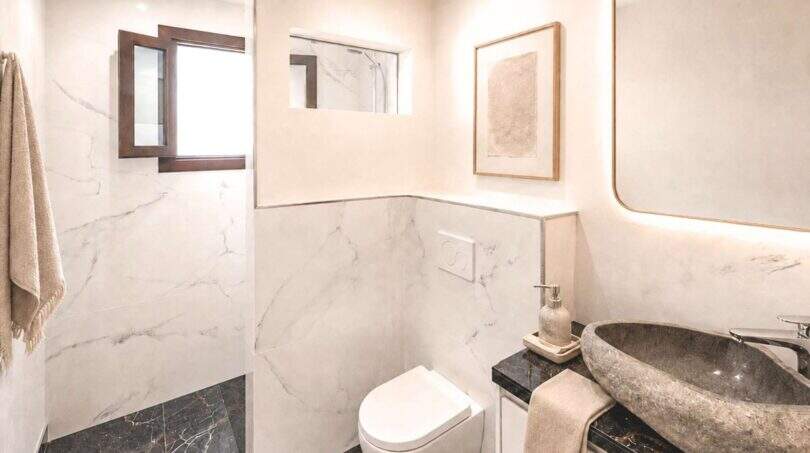 Modernes Badezimmer mit Marmorwänden, Naturstein-Waschbecken und elegantem Design in Wohnung in Felanitx
