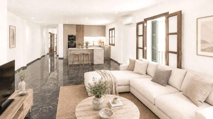 Helles Wohnzimmer mit cremefarbenem Sofa, dunklem Marmorboden und offener Küche in Felanitx