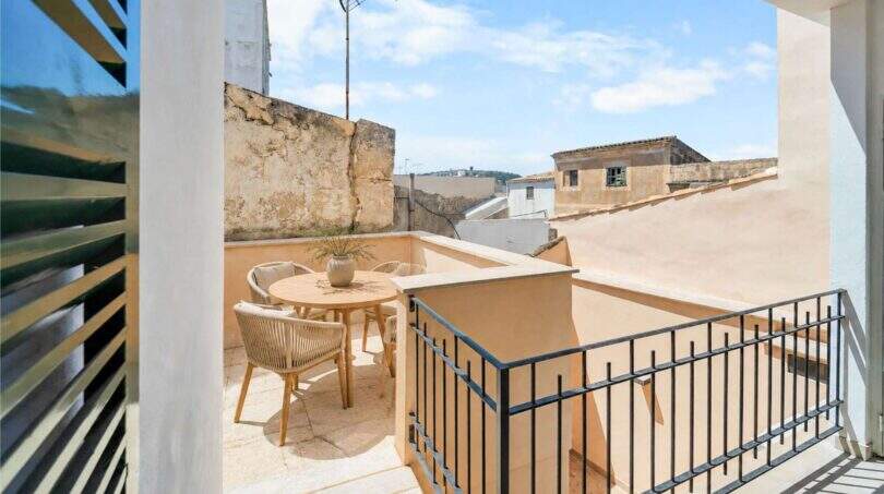 Sonnige Dachterrasse mit Rattanmöbeln und Blick auf historische Altstadtdächer in Felanitx