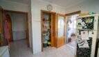 Küche mit Vorratsschrank, Kühlschrank, Wanduhr und Zugang zur Terrasse im Einfamilienhaus Porto Colom