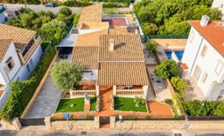 Aerial view of a Mediterranean single-family home in Porto Colom with terracotta roof, well-maintained garden and pool.