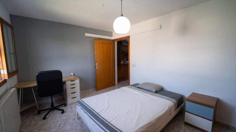 Helles Schlafzimmer mit Doppelbett, Schreibtisch und Pendelleuchte im Einfamilienhaus Porto Colom
