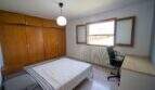 Helles Schlafzimmer mit Holzeinbauschrank, Doppelbett, Schreibtisch und Fenster mit Außenblick in Portocolom