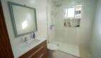 Modernes Badezimmer mit Glasdusche, WC und Holzwaschtisch im Einfamilienhaus Porto Colom