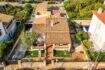 Luftaufnahme eines charmanten Einfamilienhauses in Porto Colom mit Terrakottadach, gepflegtem Garten und Pool.