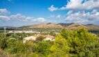 Panoramablick auf Grundstück in Capdepera mit mediterraner Vegetation, Landhäusern und imposanter Bergkulisse.