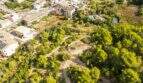 Luftaufnahme eines 32.000 m² Grundstücks in Capdepera mit üppiger Vegetation, Wegen und angrenzender Bebauung.