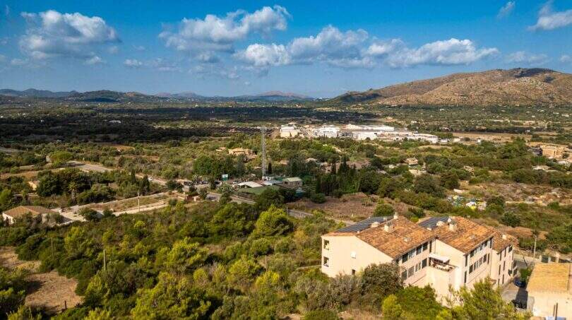 Luftaufnahme eines 32.000 m² Grundstücks in Capdepera mit Bergpanorama, Grünflächen und mediterraner Vegetation.