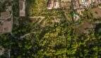 Luftaufnahme eines 32.000 m² Grundstücks in Capdepera mit üppiger Vegetation, Wohnhäusern und Solaranlagen.