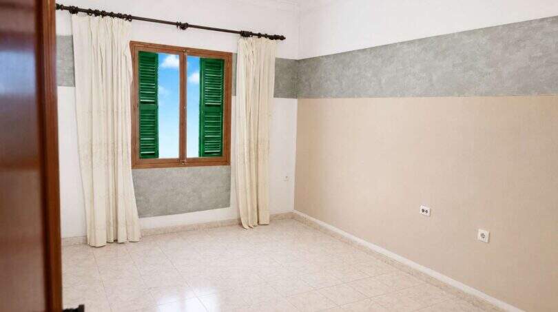Leeres Zimmer mit Fliesenboden, grünen Fensterläden und zweifarbiger Wand in Wohnung Palma
