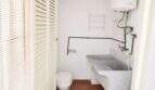 Kleines Bad mit WC, Granitwaschbecken, Warmwasserboiler und Fensterläden in renovierungsbedürftiger Wohnung Palma