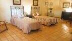 Schlafzimmer mit zwei Einzelbetten, Terrakottaboden und rustikalem Charme im Landhaus S'Aranjassa, Palma