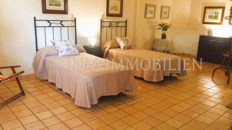 Schlafzimmer mit zwei Einzelbetten, Terrakottaboden und rustikalem Charme im Landhaus S'Aranjassa, Palma