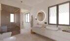 Modernes Badezimmer der Designvilla in Cala Murada mit Doppelwaschbecken, Sauna und Natursteinoptik